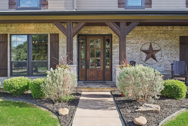 property entrance featuring brick siding and a porch
