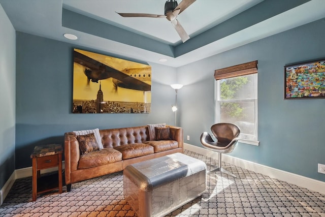 living area with a ceiling fan, baseboards, recessed lighting, and a raised ceiling