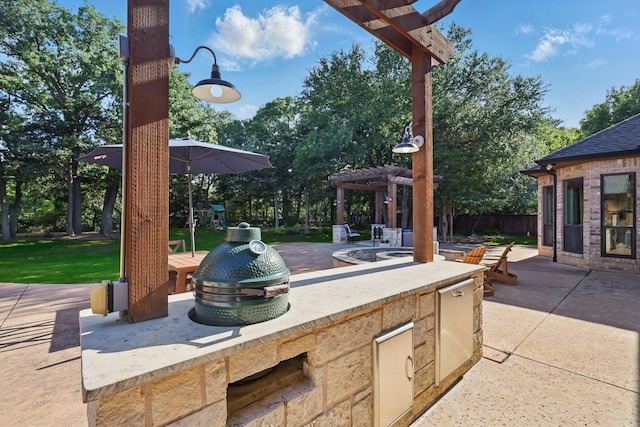 view of patio / terrace featuring a pergola, exterior kitchen, and an outdoor fire pit