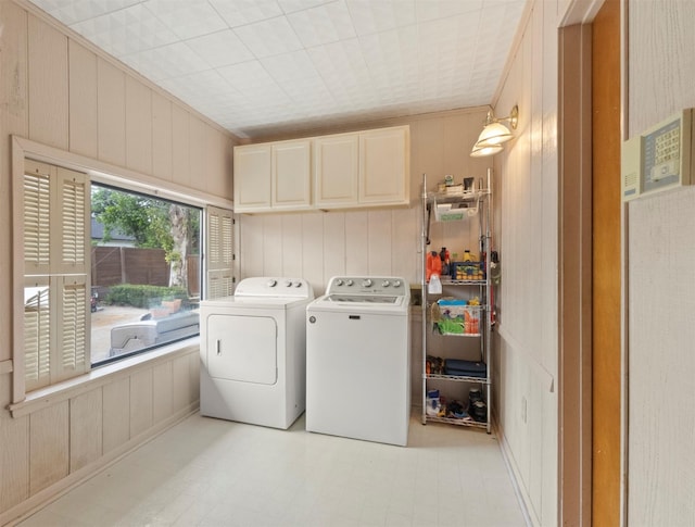10209 Solta Dr, Dallas, TX 75218 - laundry room featuring cabinet space, washer and dryer, wooden walls, and crown molding