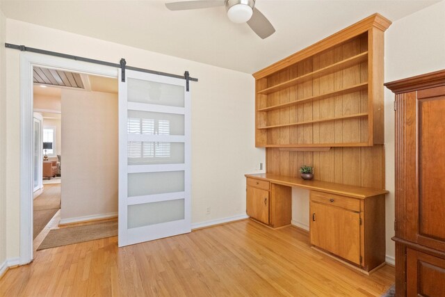 10209 Solta Dr, Dallas, TX 75218 - unfurnished office with a barn door, light wood-type flooring, ceiling fan, and baseboards