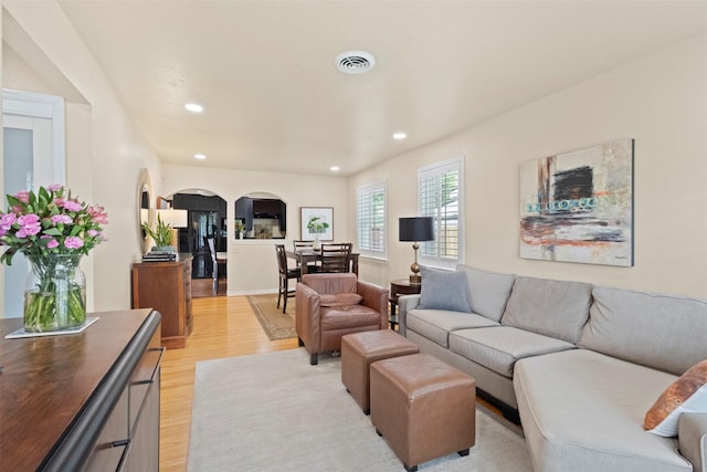 10209 Solta Dr, Dallas, TX 75218 - living area featuring arched walkways, light wood-style flooring, and recessed lighting