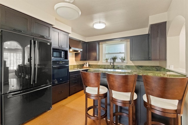 10209 Solta Dr, Dallas, TX 75218 - kitchen with black appliances, a kitchen breakfast bar, a sink, wall chimney exhaust hood, and a peninsula