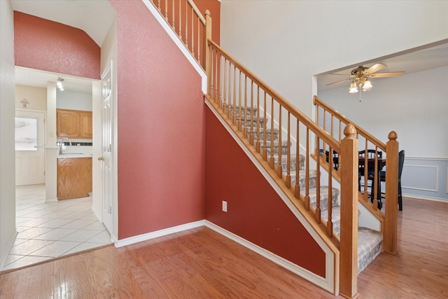 stairway with a ceiling fan and wood finished floors