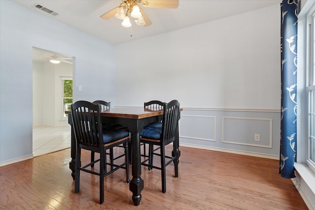 dining space featuring a ceiling fan, wood finished floors, and baseboards