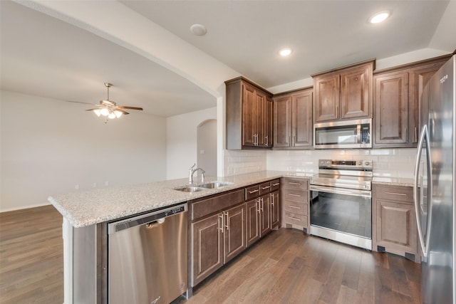 4505 Ridgehurst Ln, Fort Worth, TX 76036 - kitchen with stainless steel appliances, a sink, arched walkways, a ceiling fan, and dark wood-style flooring