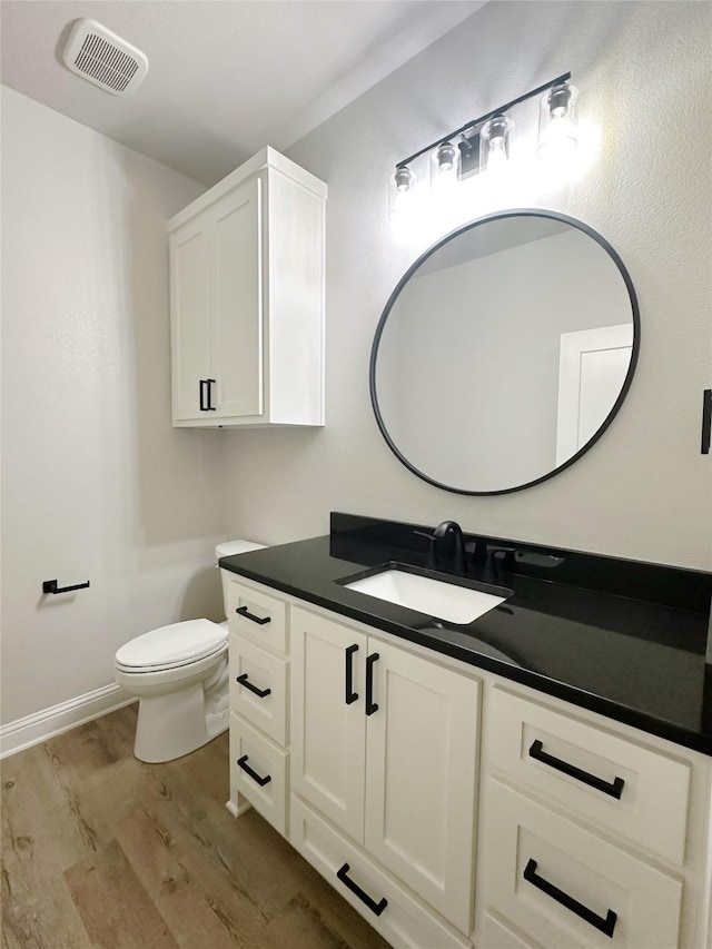 6710 Windmill Grass Ln, Abilene, TX 79606 - half bathroom with wood finished floors, vanity, and toilet
