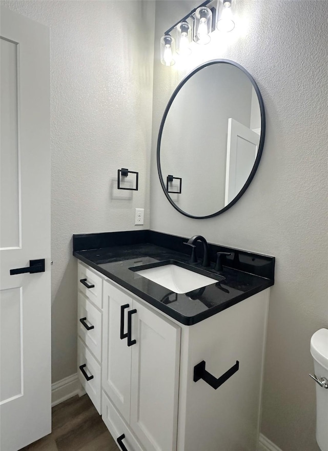 6710 Windmill Grass Ln, Abilene, TX 79606 - half bath with vanity, wood finished floors, baseboards, and toilet