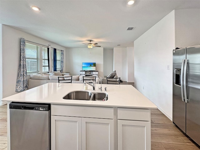 8309 Caracara Dr, Mckinney, TX 75071 - kitchen with stainless steel appliances, a sink, open floor plan, light wood-type flooring, and a ceiling fan