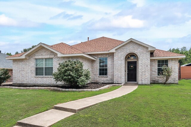 110 Redwood, Terrell, TX 75160 - view of front of house with a front lawn, a shingled roof, and brick siding