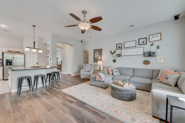 110 Redwood, Terrell, TX 75160 - living area with ceiling fan, arched walkways, light wood-type flooring, and baseboards