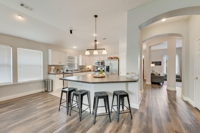 110 Redwood, Terrell, TX 75160 - kitchen featuring stainless steel appliances, light wood-style flooring, a kitchen breakfast bar, arched walkways, and recessed lighting