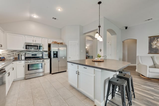 110 Redwood, Terrell, TX 75160 - kitchen featuring appliances with stainless steel finishes, arched walkways, dark countertops, and lofted ceiling