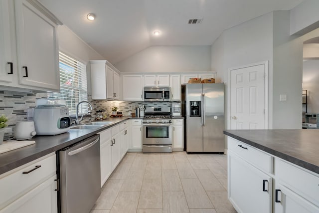 110 Redwood, Terrell, TX 75160 - kitchen with appliances with stainless steel finishes, a sink, dark countertops, vaulted ceiling, and tasteful backsplash