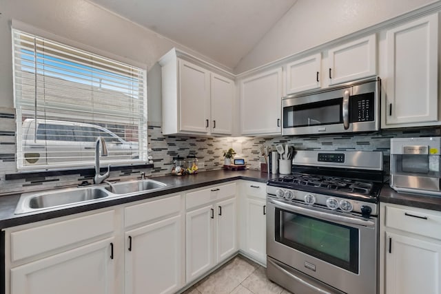 110 Redwood, Terrell, TX 75160 - kitchen featuring appliances with stainless steel finishes, lofted ceiling, a sink, decorative backsplash, and dark countertops