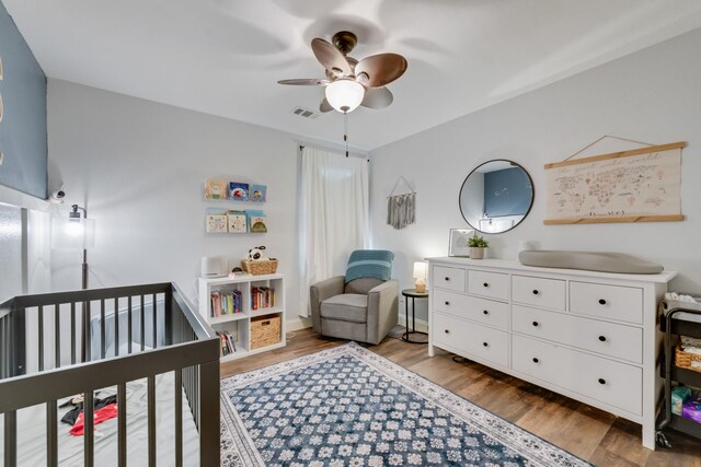 110 Redwood, Terrell, TX 75160 - bedroom featuring light wood-style flooring, a crib, ceiling fan, and baseboards
