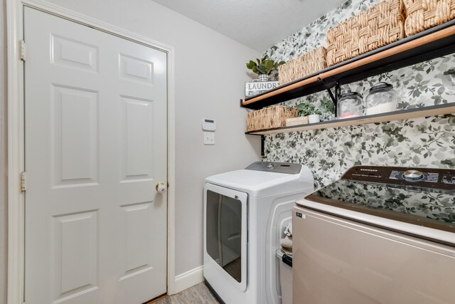110 Redwood, Terrell, TX 75160 - laundry room featuring washer and clothes dryer, light wood-style flooring, and baseboards