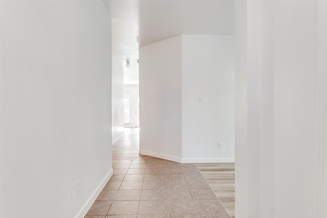 unfurnished room featuring light tile patterned flooring and baseboards