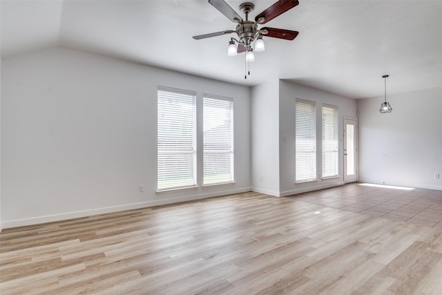 empty room with ceiling fan, light wood-style floors, baseboards, and lofted ceiling