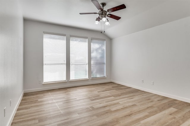 empty room featuring ceiling fan, baseboards, light wood-type flooring, and vaulted ceiling