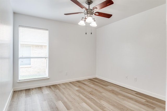 spare room with light wood-style floors, a ceiling fan, and baseboards