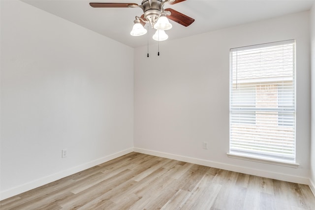 spare room with a ceiling fan, light wood-style flooring, and baseboards