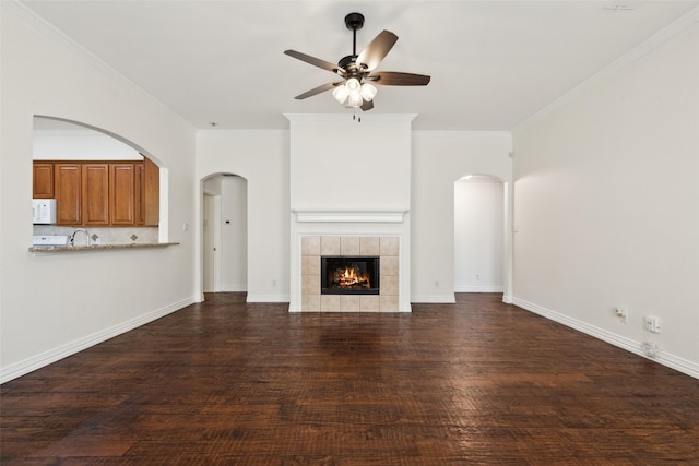9709 Maryville Ln, Fort Worth, TX 76108 - unfurnished living room with a ceiling fan, wood finished floors, crown molding, a tile fireplace, and arched walkways
