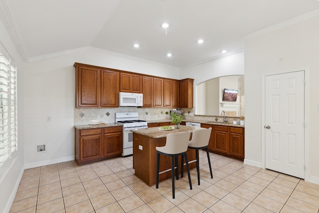 9709 Maryville Ln, Fort Worth, TX 76108 - kitchen featuring white appliances, arched walkways, a center island, ornamental molding, and brown cabinetry