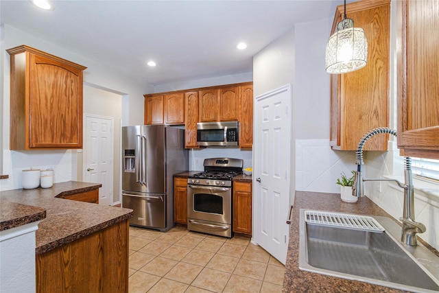 9908 Summer Sweet Dr, Mckinney, TX 75072 - kitchen featuring appliances with stainless steel finishes, a sink, dark countertops, light tile patterned floors, and decorative light fixtures