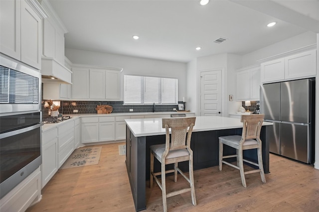 513 Fieldstone Ln, Haslet, TX 76052 - kitchen with stainless steel appliances, a center island, backsplash, light countertops, and white cabinets