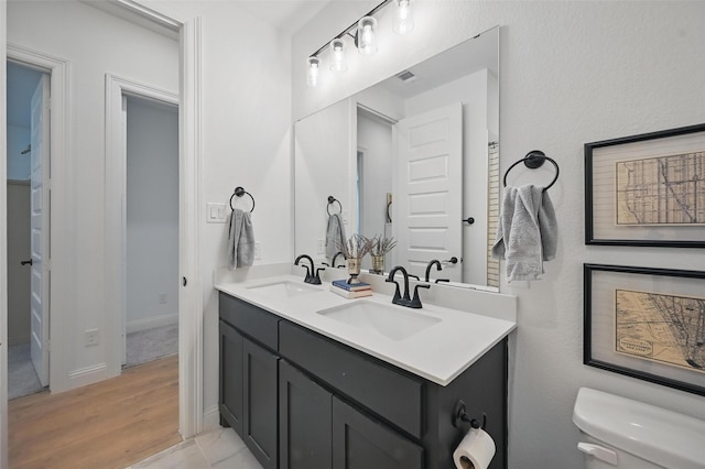 513 Fieldstone Ln, Haslet, TX 76052 - bathroom with toilet, double vanity, and wood finished floors