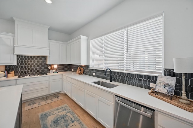 513 Fieldstone Ln, Haslet, TX 76052 - kitchen with appliances with stainless steel finishes, a sink, white cabinets, light wood-style flooring, and backsplash