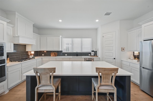 513 Fieldstone Ln, Haslet, TX 76052 - kitchen featuring stainless steel appliances, a sink, a breakfast bar area, decorative backsplash, and recessed lighting