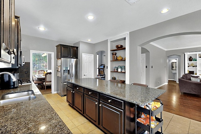 2202 Hodges Pl, Mansfield, TX 76063 - kitchen featuring stainless steel fridge, a sink, built in features, light tile patterned floors, and arched walkways