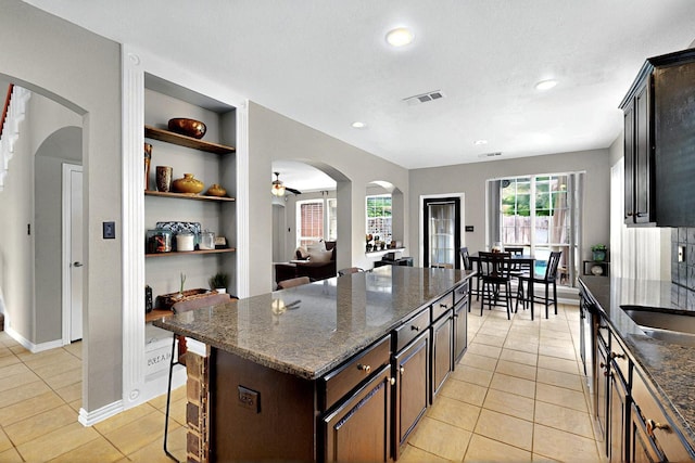 2202 Hodges Pl, Mansfield, TX 76063 - kitchen featuring built in features, light tile patterned floors, arched walkways, open shelves, and recessed lighting