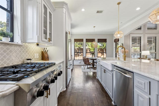 11353 Seaside Ln, Frisco, TX 75035 - kitchen featuring stainless steel appliances, a sink, dark wood-type flooring, tasteful backsplash, and glass insert cabinets