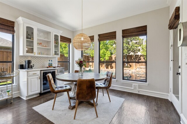 11353 Seaside Ln, Frisco, TX 75035 - dining area with wine cooler, plenty of natural light, a dry bar, dark wood-style flooring, and crown molding
