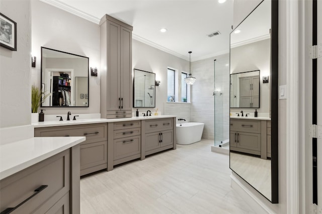 11353 Seaside Ln, Frisco, TX 75035 - full bathroom featuring a shower stall, a freestanding bath, crown molding, two vanities, and recessed lighting