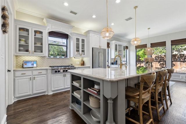 11353 Seaside Ln, Frisco, TX 75035 - kitchen with stainless steel appliances, a kitchen island with sink, open shelves, tasteful backsplash, and white cabinetry