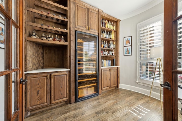 11353 Seaside Ln, Frisco, TX 75035 - bar area with beverage cooler, ornamental molding, wood finished floors, and baseboards