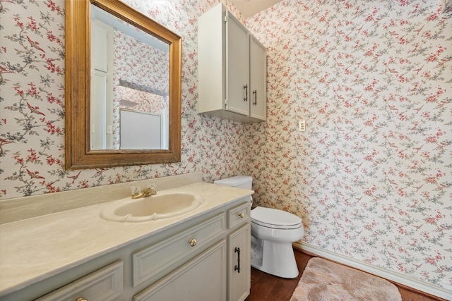 301 Peachtree St, Fairfield, TX 75840 - bathroom featuring wallpapered walls, vanity, wood finished floors, toilet, and baseboards