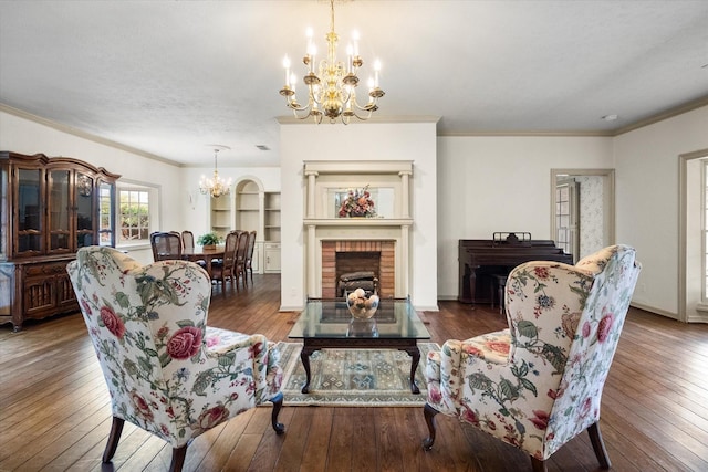 301 Peachtree St, Fairfield, TX 75840 - living area with a chandelier, hardwood / wood-style flooring, crown molding, a brick fireplace, and baseboards