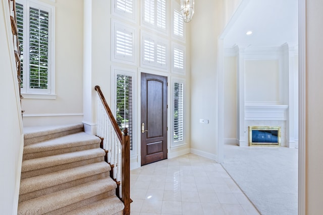 3441 Mount Vernon Way, Plano, TX 75025 - foyer with stairs, a high ceiling, light tile patterned floors, baseboards, and a glass covered fireplace