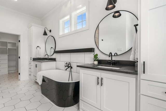 205 Oak Creek Dr, Tool, TX 75143 - bathroom featuring ornamental molding, a freestanding bath, two vanities, and a spacious closet