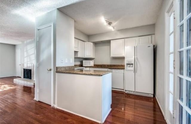 5232 Fleetwood Oaks Ave Unit 216, Dallas, TX 75235 - kitchen featuring white appliances, white cabinetry, a textured ceiling, dark wood finished floors, and healthy amount of natural light