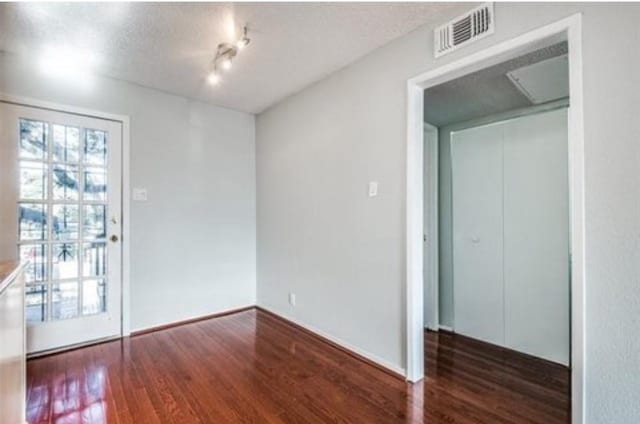 5232 Fleetwood Oaks Ave Unit 216, Dallas, TX 75235 - spare room featuring wood finished floors, a textured ceiling, and baseboards