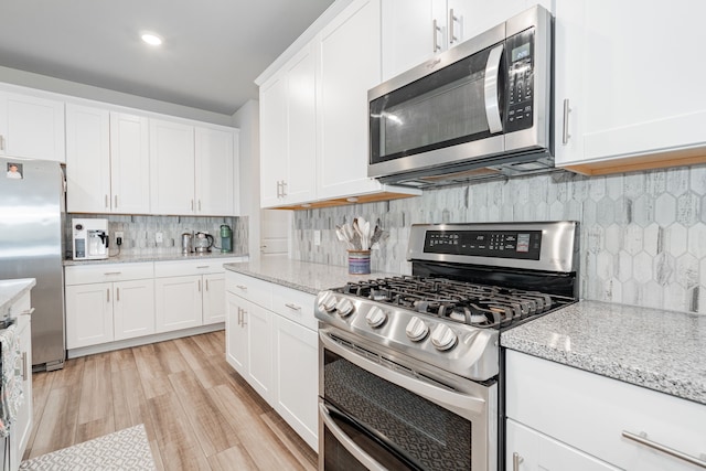 333 Mohan Dr, Royse City, TX 75189 - kitchen featuring stainless steel appliances, backsplash, white cabinets, light wood-style flooring, and light stone countertops