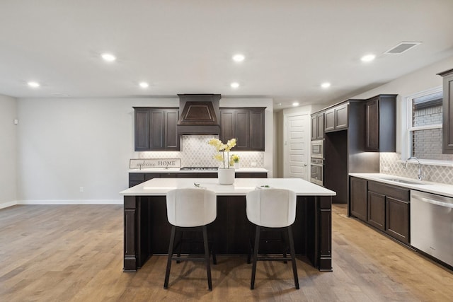 3537 W Cheney Ave, Celina, TX 75009 - kitchen with custom exhaust hood, stainless steel appliances, backsplash, a kitchen island, and light countertops