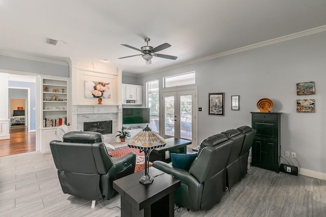 1220 Mount Gilead Rd, Keller, TX 76262 - living room with french doors, a ceiling fan, ornamental molding, light wood-type flooring, and a stone fireplace