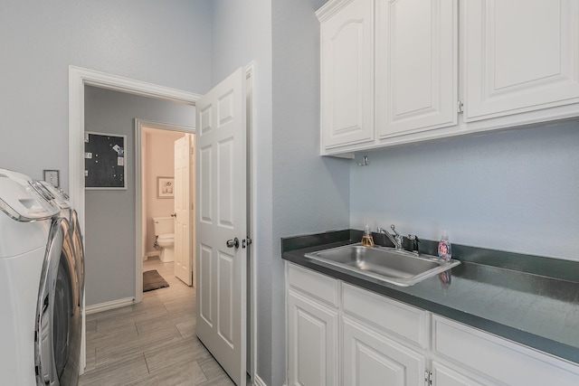 1220 Mount Gilead Rd, Keller, TX 76262 - washroom featuring cabinet space, baseboards, washing machine and clothes dryer, and light wood-style flooring